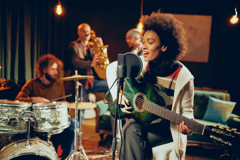 female musician singing while playing guitar